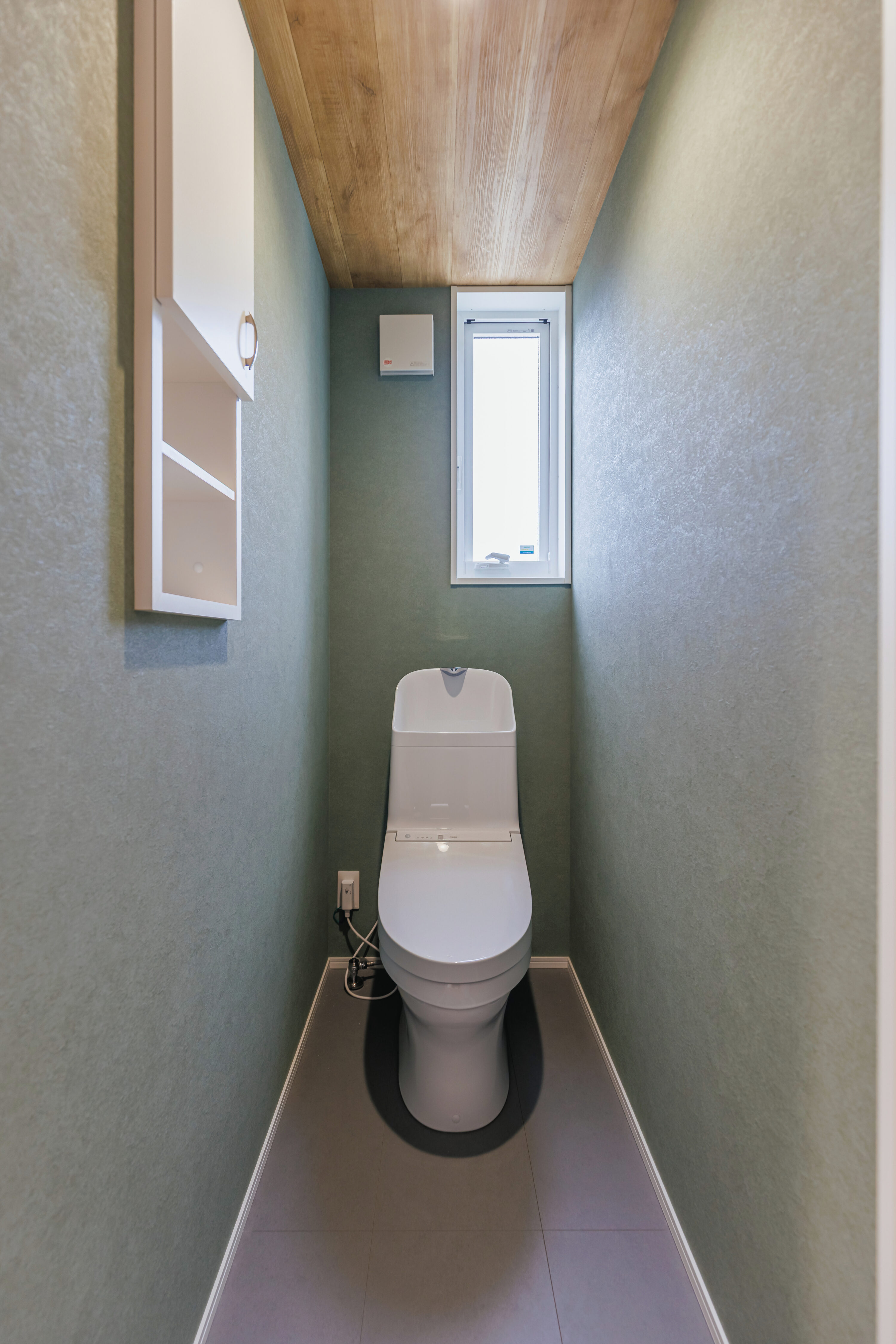 モスグリーンの外壁と木が調和する、静かな佇まいの家の写真22