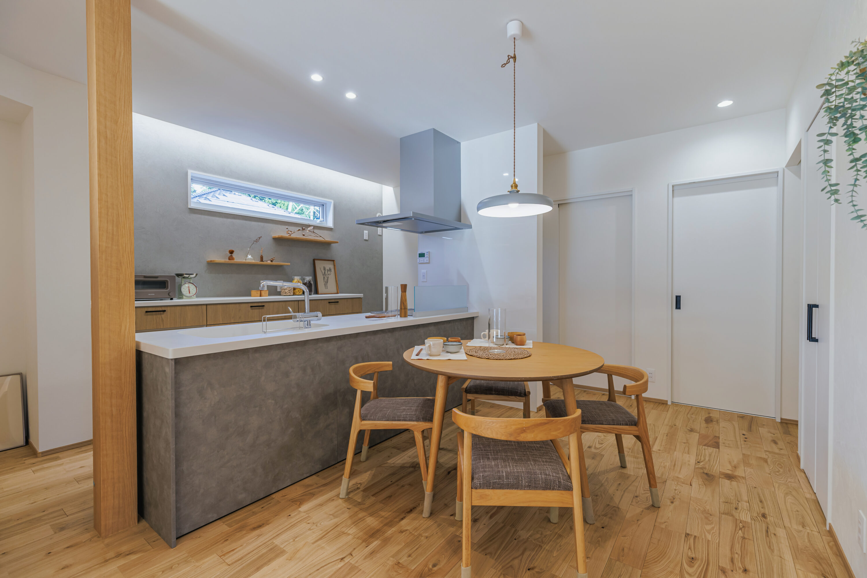 モスグリーンの外壁と木が調和する、静かな佇まいの家の写真17