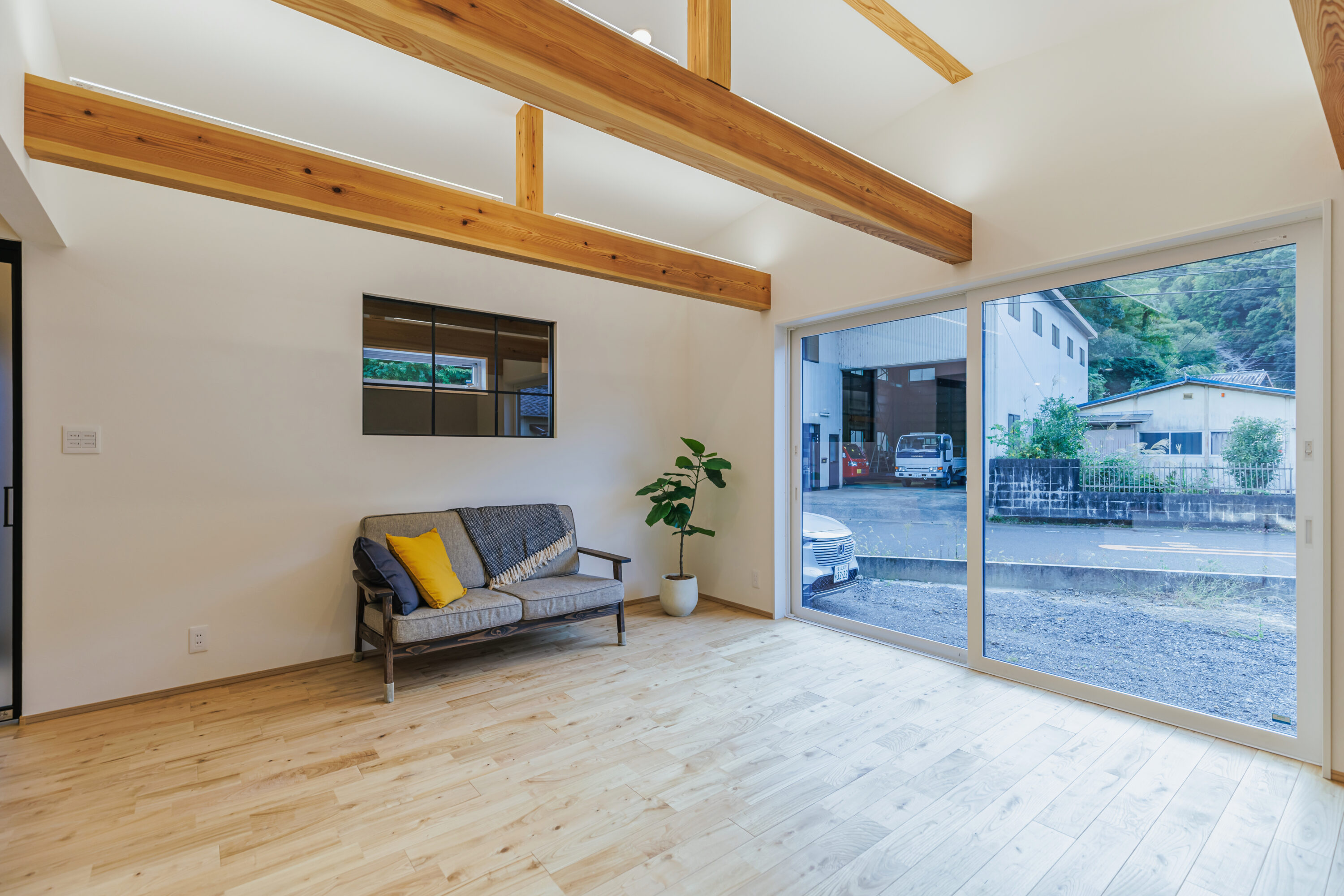 モスグリーンの外壁と木が調和する、静かな佇まいの家の写真9