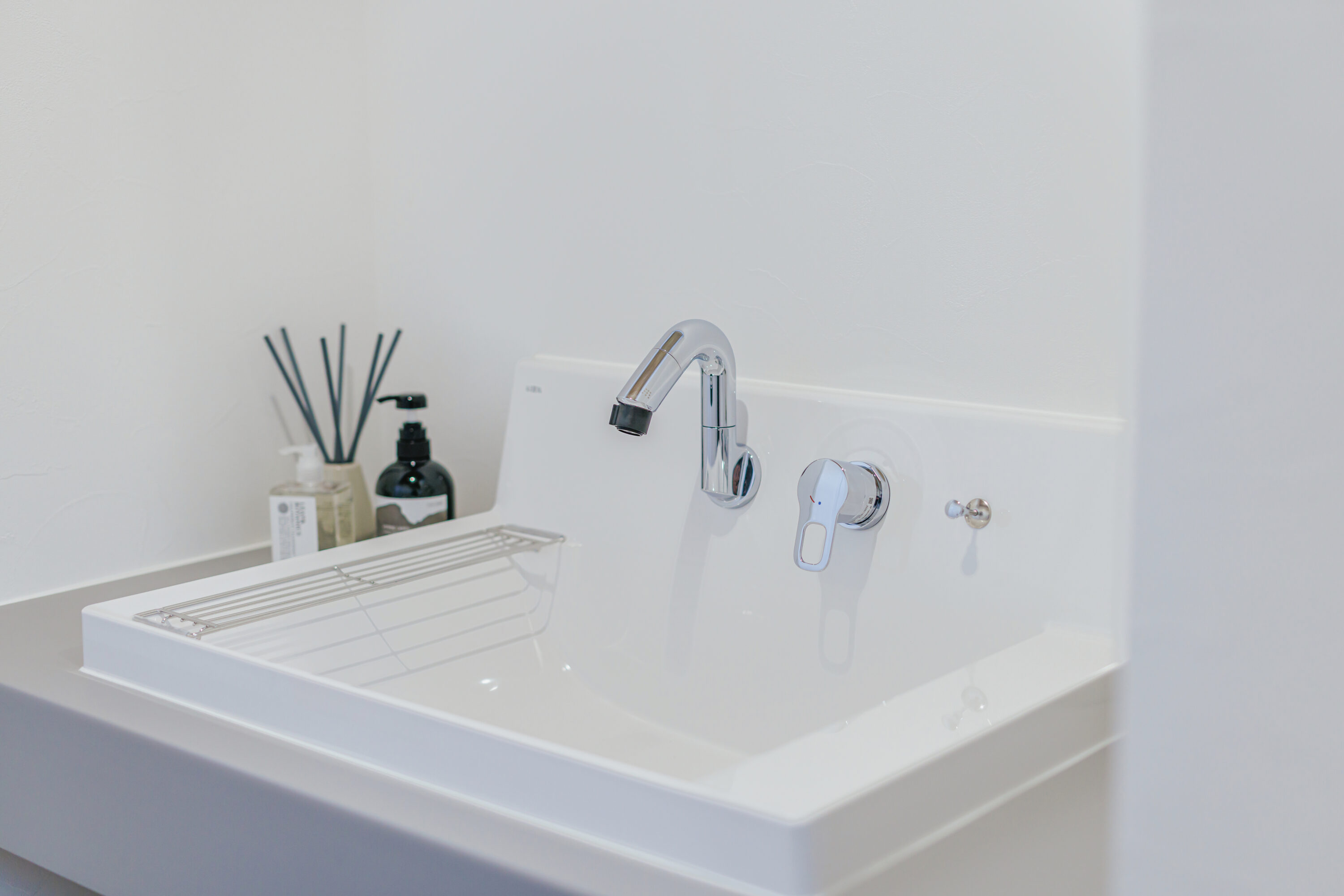 モスグリーンの外壁と木が調和する、静かな佇まいの家の写真4