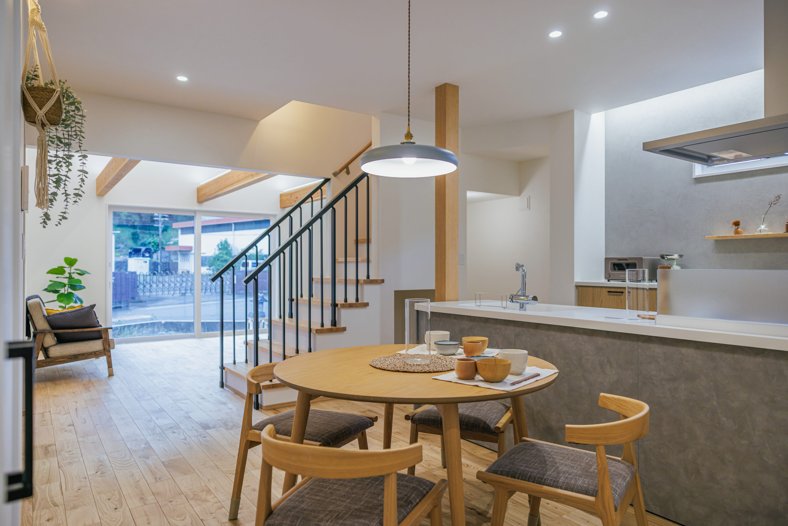 モスグリーンの外壁と木が調和する、静かな佇まいの家の写真3