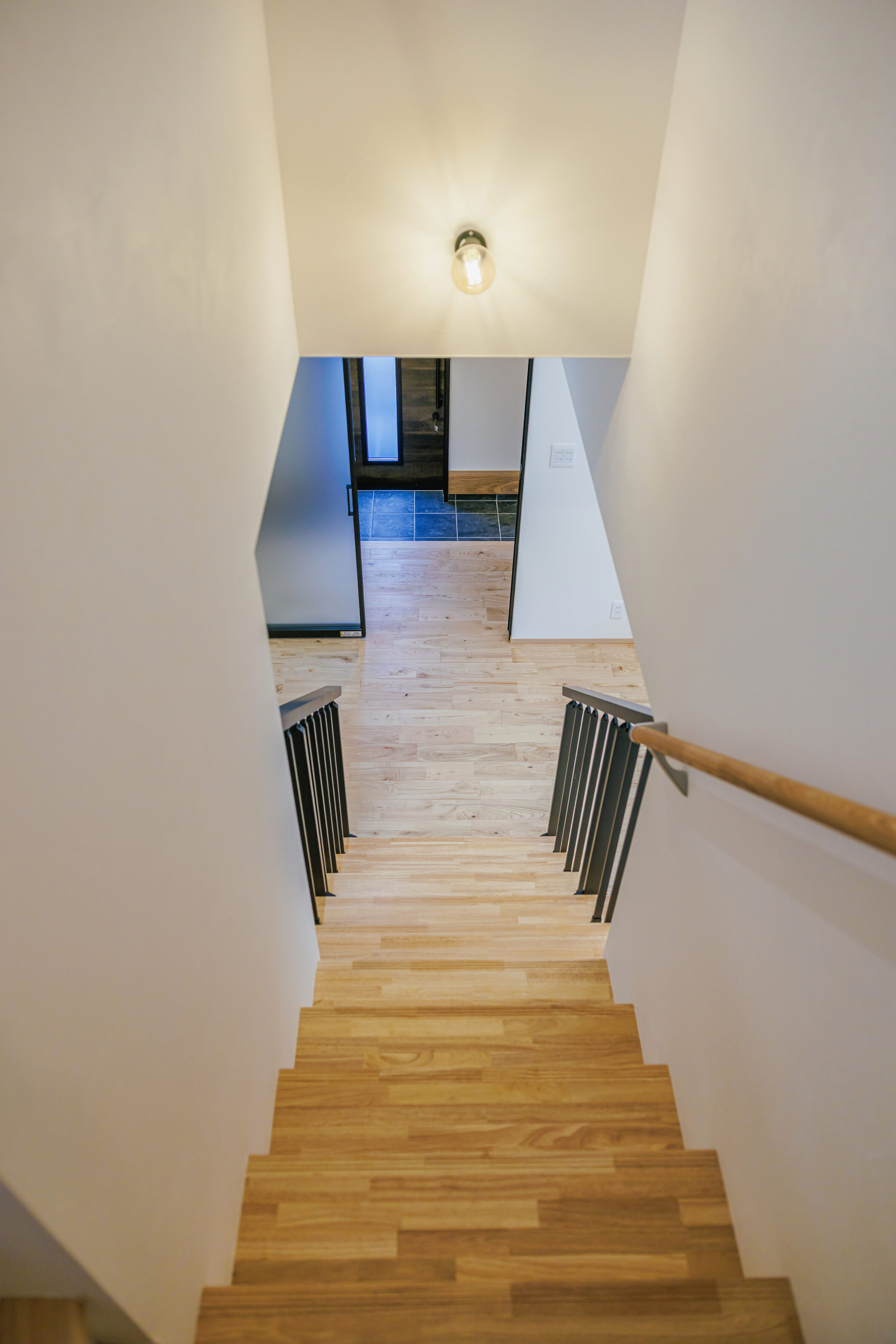 モスグリーンの外壁と木が調和する、静かな佇まいの家の写真2